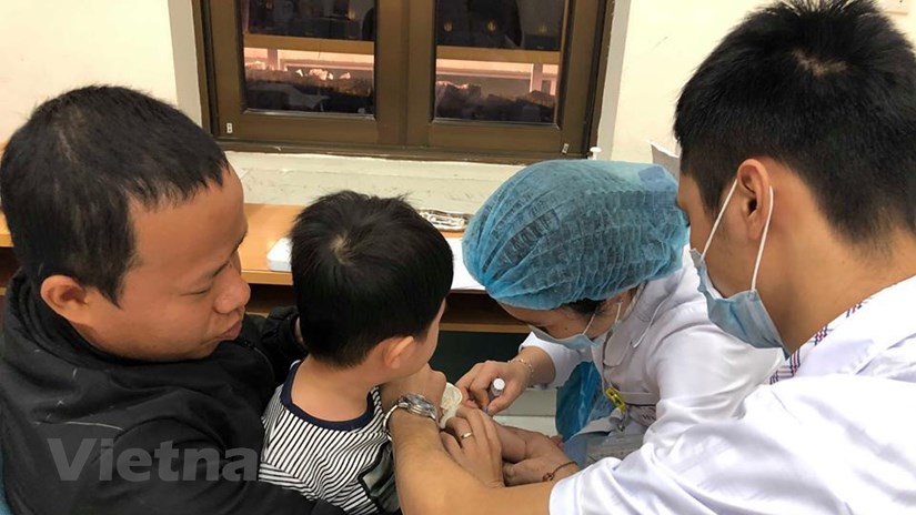  Bác sỹ lấy máu xét nghiệm cho trẻ. (Ảnh: PV/Vietnam+)