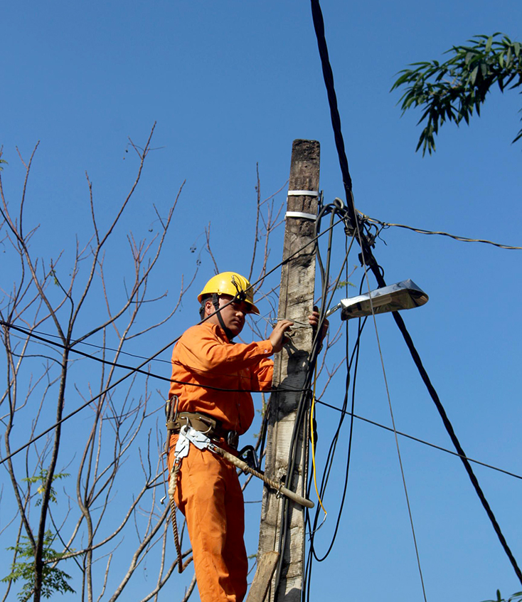 Công nhân Điện lực Minh Hóa thi công thay thế đường dây sau công tơ miễn phí cho khách hàng.