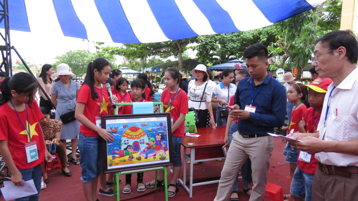 Các em học sinh Trường tiểu học Đồng Phú giới thiệu về bức tranh vẽ ngôi trường mơ ước của mình với Ban giám khảo.