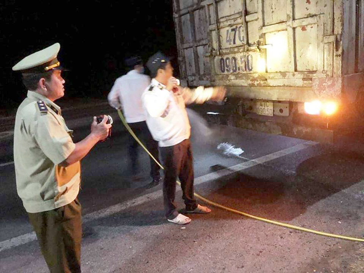 Lực lượng chức năng kiểm tra và phun tiêu độc khử trùng các phương tiện giao thông có chở động vật khi qua địa bàn huyện Quảng Trạch.