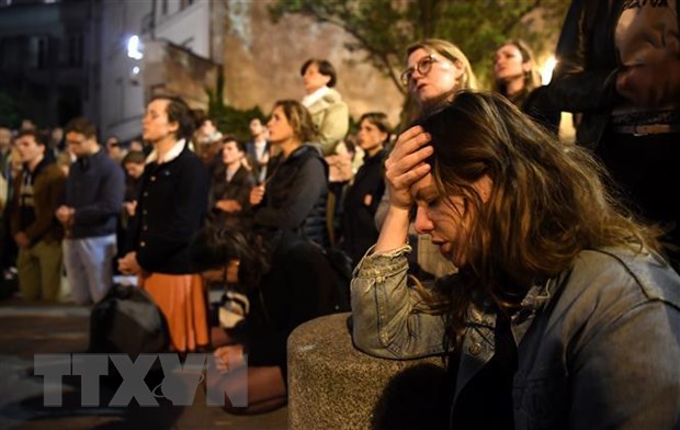 Cau truc Nha tho Duc Ba Paris duoc bao ve nguyen ven sau vu chay hinh anh 1Người dân cầu nguyện khi chứng kiến vụ hỏa hoạn tại Nhà thờ Đức Bà ở Paris, Pháp ngày 15/4/2019. (Ảnh: AFP/TTXVN)