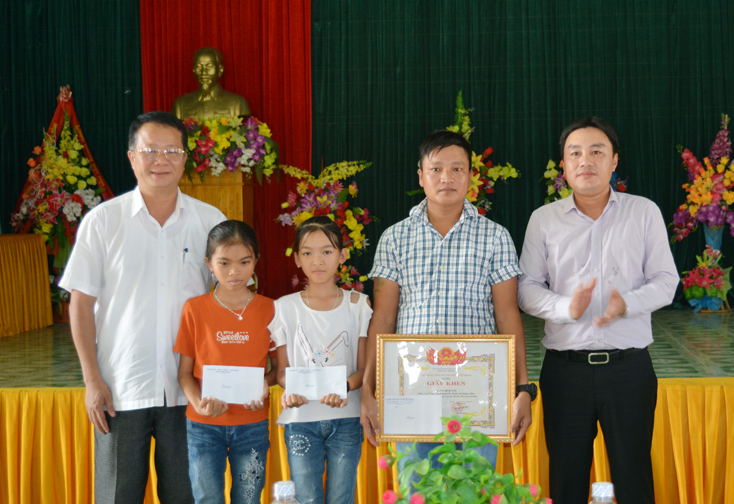 Lãnh đạo huyện Bố Trạch trao giấy khen biểu dương anh Võ Thái Sơn và trao quà chúc mừng hai em nhỏ được cứu sống.