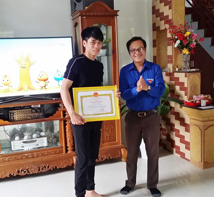 Đại diện lãnh đạo Huyện đoàn Quảng Trạch trao giấy khen của Chủ tịch UBND huyện cho em Phạm Thế Cường