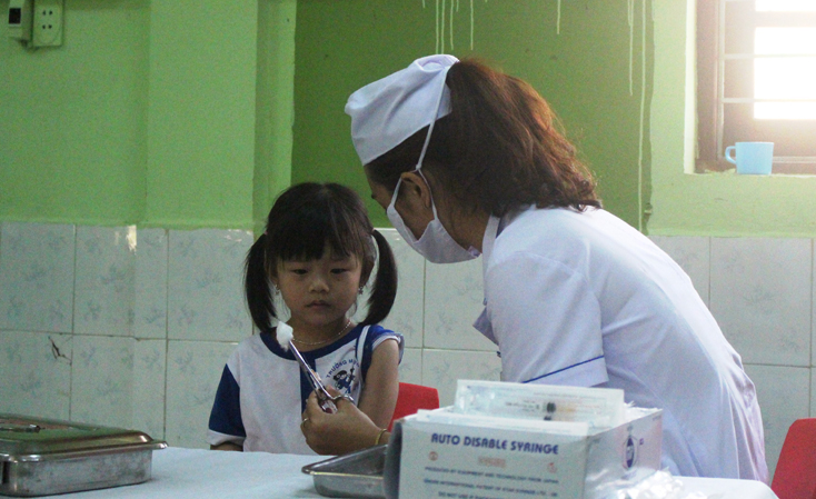Các y bác sĩ tiêm vắc xin MR cho trẻ tại Trường mầm non Bắc Lý (TP. Đồng Hới).