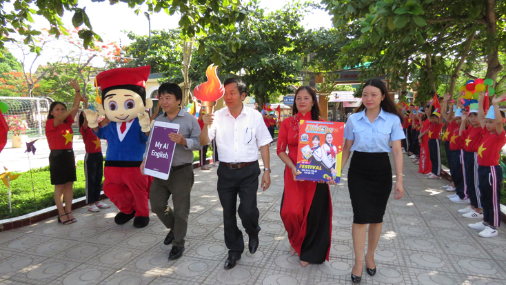Đại diện lãnh đạo Sở GD-ĐT, Báo Nhi Đồng, Tỉnh Đoàn đón ngọn đuốc biểu trưng cho niềm đam mê học Tiếng Anh.