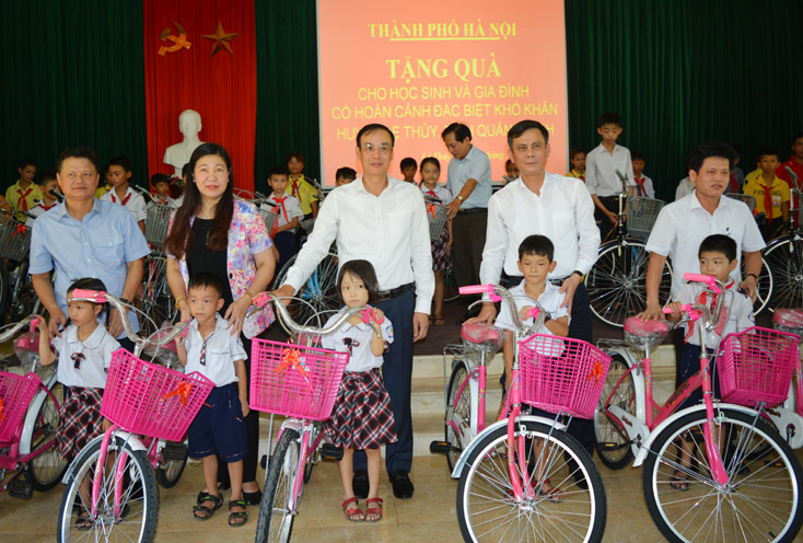 Đồng chí Trần Thắng, Phó Bí thư Thường trực Tỉnh uỷ và đoàn công tác thành phố Hà Nội trao tặng xe đạp cho các em học sinh xã Cam Thủy.