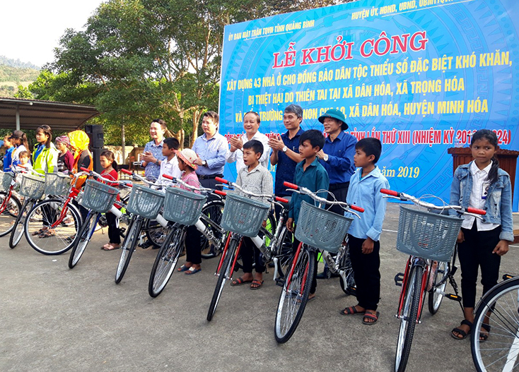 Các đồng chí lãnh đạo Ủy ban MTTQ Việt Nam tỉnh và huyện Minh Hóa tặng xe đạp cho các em học sinh xã Trọng Hóa. 