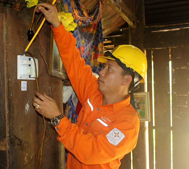 Công nhân PC Quảng Bình hỗ trợ khách hàng thay thế miễn phí thiết bị điện sau công tơ.