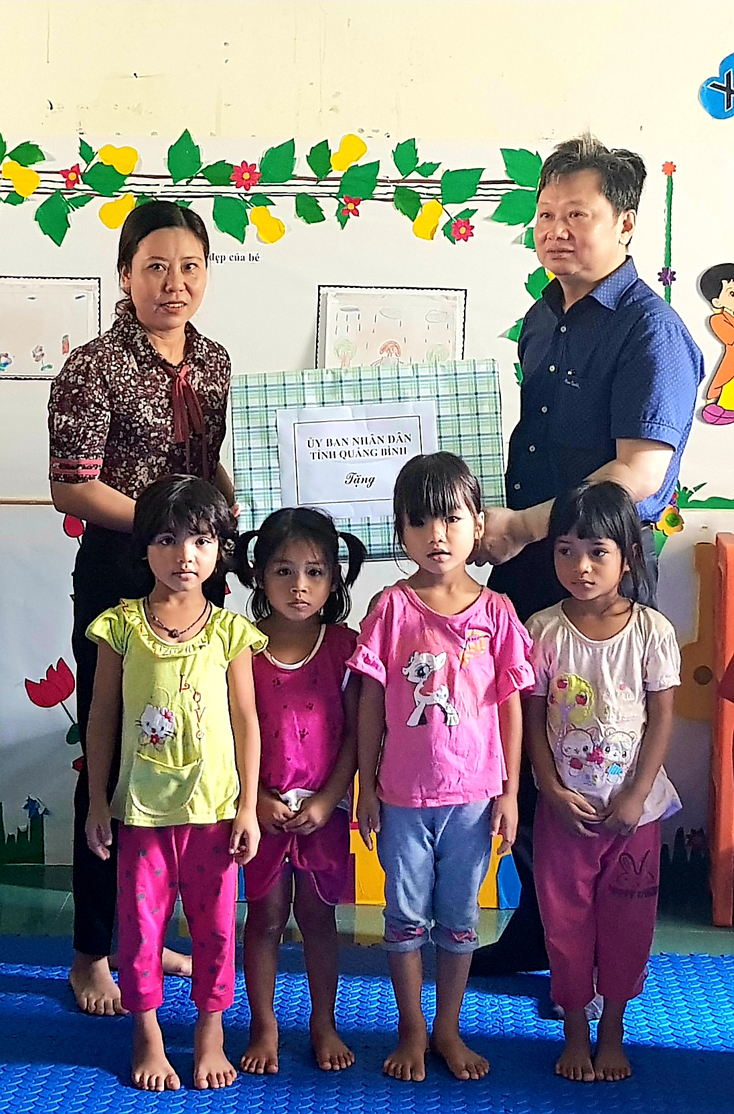 Đồng chí Nguyễn Tiến Hoàng, Phó Chủ tịch UBND tỉnh tặng quà cho giáo viên và học sinh điểm trường mầm non Eo bù.  