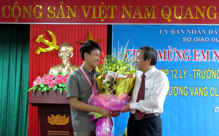 Đồng chí Bí thư Tỉnh ủy Hoàng Đăng Quang tặng hoa cho em Nguyễn Thế Quỳnh, một trong những tấm gương điển hình thực hiện Chỉ thị 05.