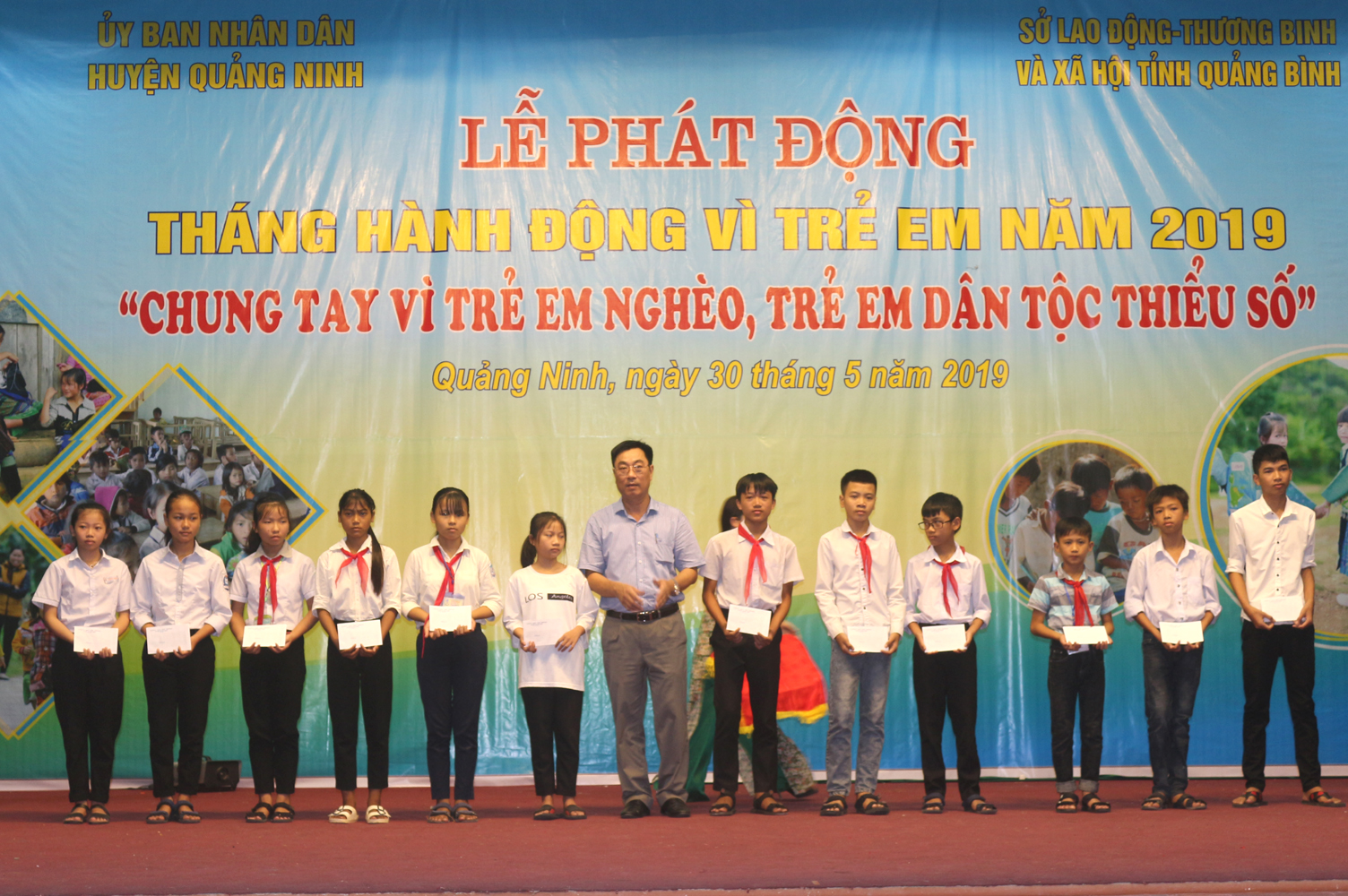Đại diện lãnh đạo huyện Quảng Ninh trao thưởng cho các học sinh giỏi có hoàn cảnh khó khăn.