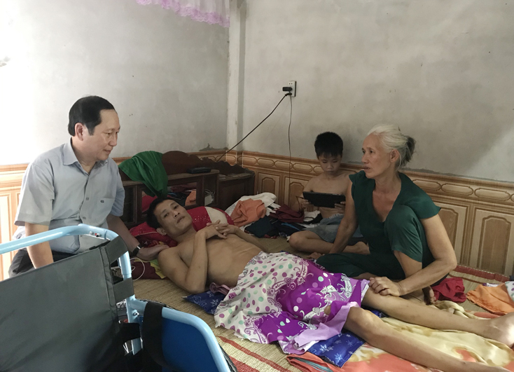 Ông Nguyễn Văn Sơn, Phó Chủ tịch Thường trực Hội Khuyến học tỉnh trao xe lăn và tiền chữa bệnh cho anh Phạm Văn Thuận.