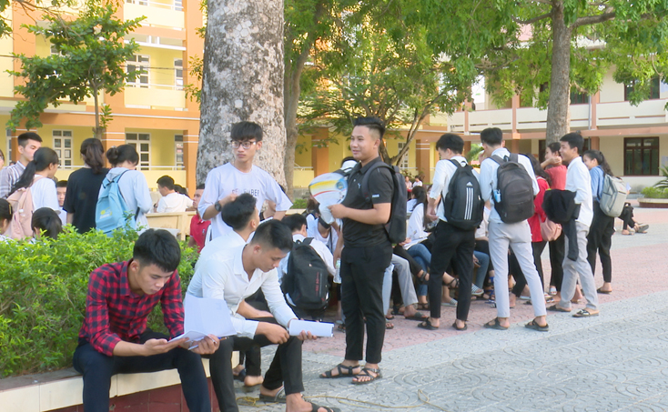 Các thí sinh tại điểm thi Trường THPT Lương Thế Vinh (phường Ba Đồn) xem lại bài trước giờ thi.