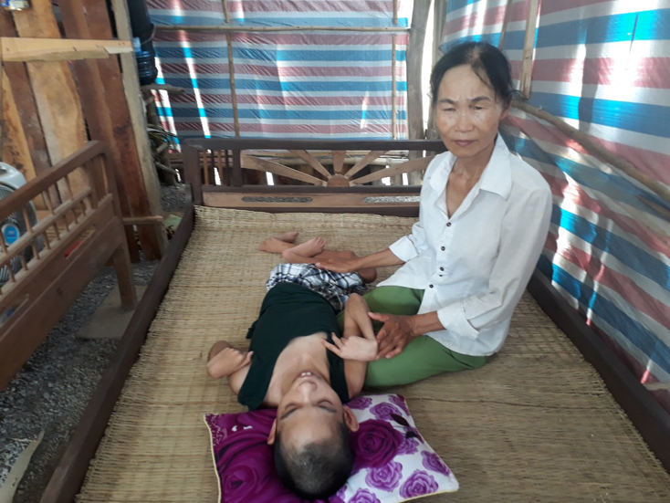 Hai mẹ con chị Quang trong căn nhà được che phủ bởi những tấm bạt.