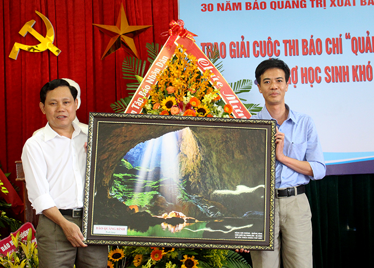 Đồng chí Cao Trường Sơn, Phó tổng biên tập Báo Quảng Bình tặng bức tranh về Phong Nha-Kẻ Bàng cho Báo Quảng Trị tại lễ kỷ niệm.