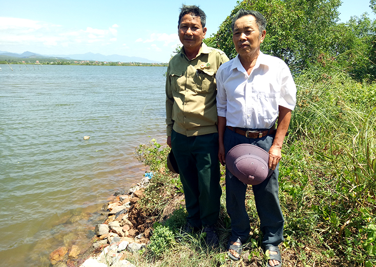 Ông Nguyễn Lưu (bên phải)-chiến sỹ dân quân trực chiến thôn Trúc Ly và ông Đặng Quốc Trị, Phó Chủ tịch Hội Cựu TNXP huyện Quảng Ninh đứng tại di tích bến phà 2 Trúc Ly.