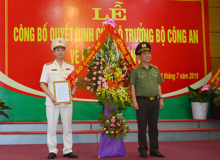 Trung tướng Nguyễn Văn Sơn, Thứ trưởng Bộ Công an trao quyết định và tặng hoa chúc mừng đại tá Trần Hải Quân