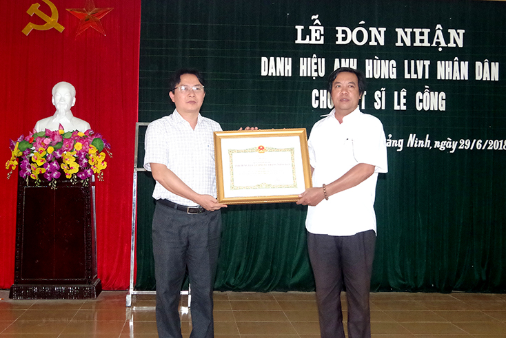 Đại diện lãnh đạo huyện Quảng Ninh trao danh hiệu Anh hùng LLVTND cho thân nhân liệt sỹ Lê Cồng.