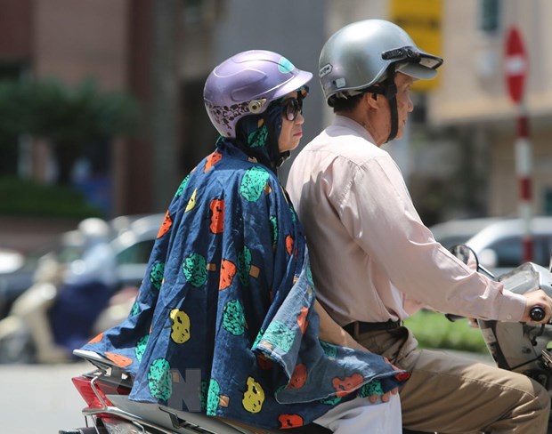  Người dân ra đường với trang phục kín mít để tránh cái nắng gay gắt. (Ảnh: Thành Đạt/TTXVN)