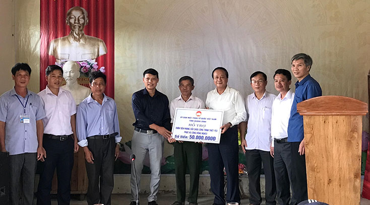 Đồng chí Chủ tịch Ủy ban MTTQVN tỉnh Trần Văn Tuân trao số tiền 50 triệu đồng hỗ trợ sửa chữa công trình thiết yếu phục vụ cộng đồng nghèo huyện Tuyên Hóa
