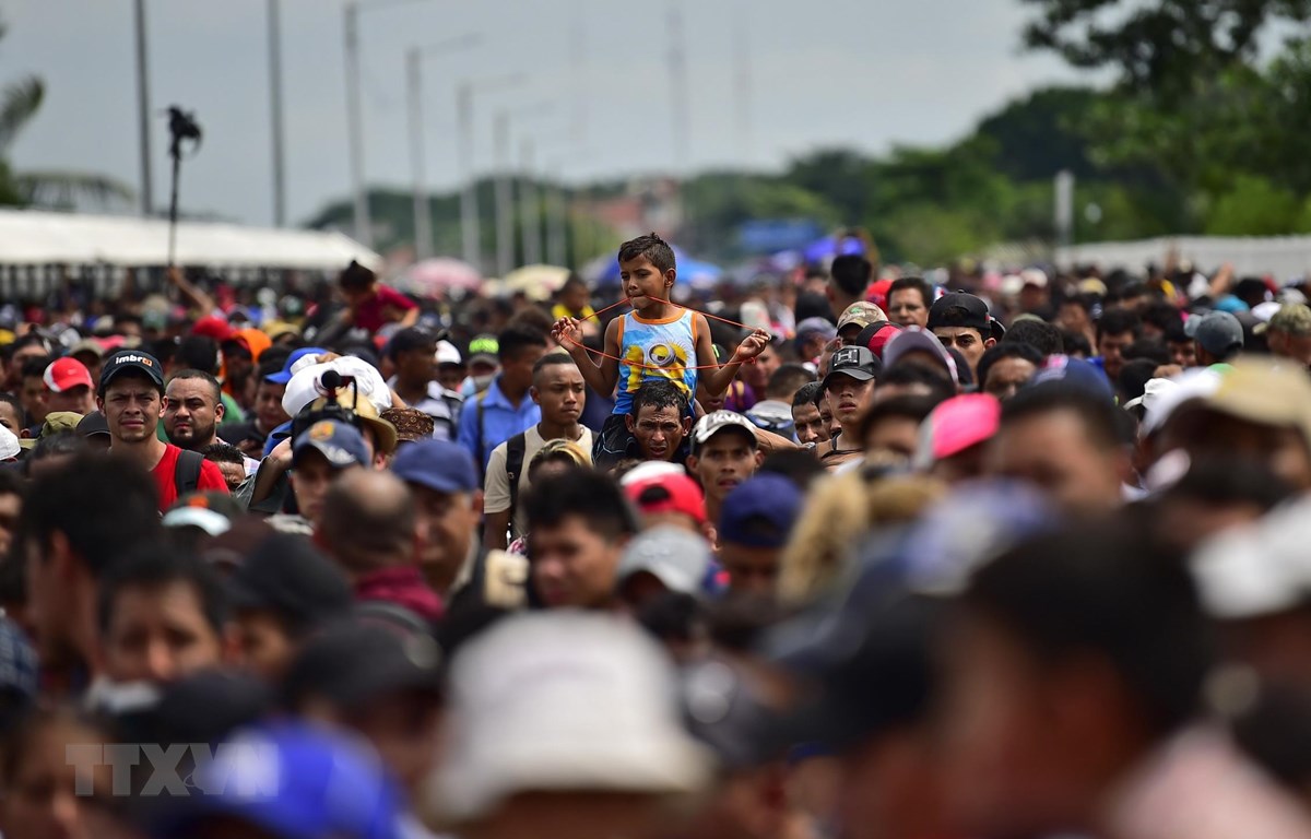 Người di cư trong hành trình tới Mỹ tại cây cầu biên giới Guatemala-Mexico. (Ảnh: AFP/ TTXVN)