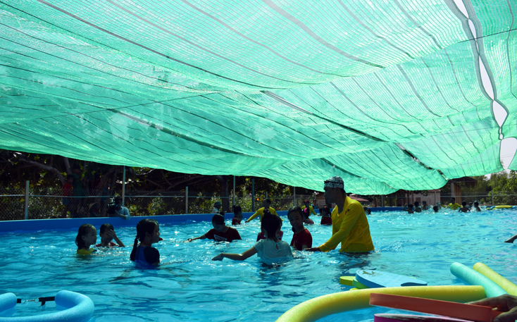 Các tình nguyện viên, hướng dẫn viên tham gia thực hành miễn phí kỹ năng về bơi lội cho học sinh