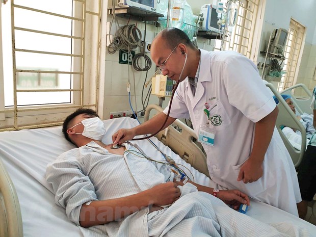 Tiến sỹ Lê Xuân Luật khám cho bệnh nhân điều trị sốt xuất huyết tại Trung tâm Nhiệt đới. (Ảnh: T.G/Vietnam+)