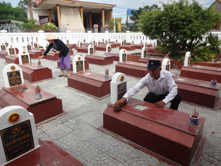 Vợ chồng CCB Phan Văn Xuân đang chăm sóc cho các phần mộ tại Nghĩa trang liệt sỹ xã Đức Trạch.