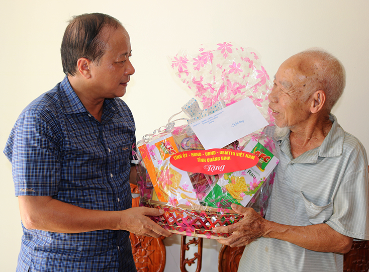 Đồng chí Trần Văn Tuân thăm và tặng quà cho ông Nguyễn Đức An, thương binh hạng ¼ ở xã Tiến Hóa, huyện Tuyên Hóa.