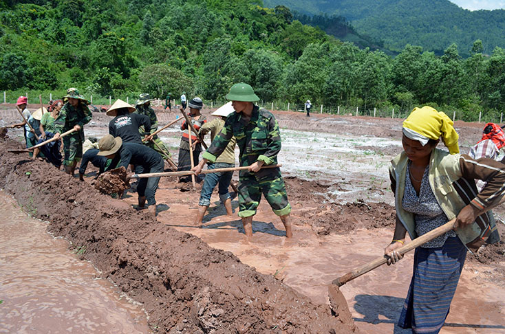 Cán bộ, chiến sỹ Biên phòng giúp bà con đồng bào Rục (xã Thượng Hóa, huyện Minh Hóa) làm đất sản xuất nông nghiệp. 
