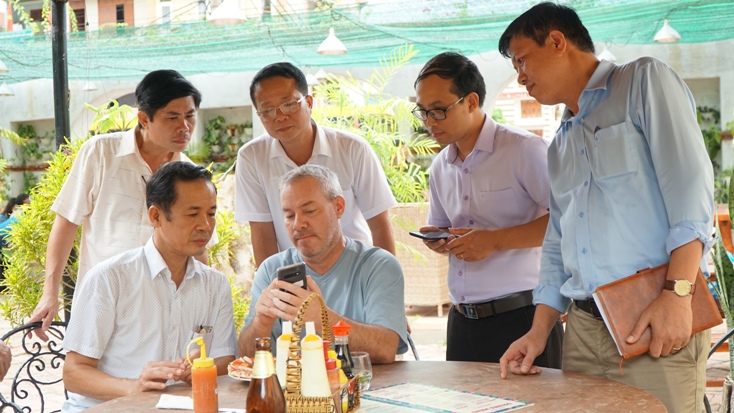 Đồng chí Trần Công Thuật trò chuyện cùng du khách nước ngoài. 