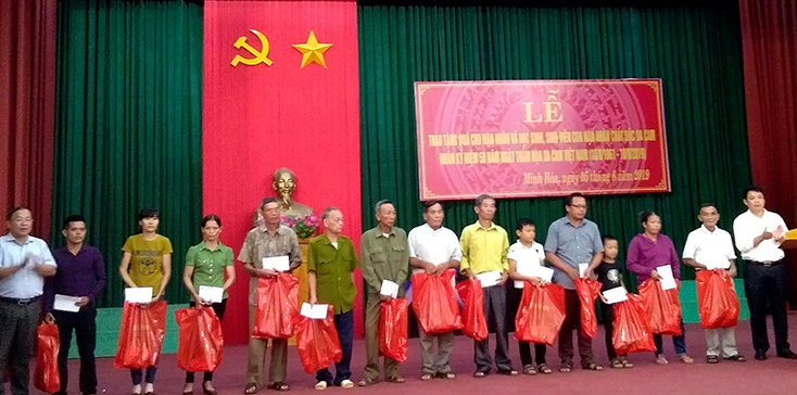 Đại diện lãnh đạo huyện Minh Hóa tặng quà cho nạn nhân và con nạn nhân chất độc da cam trên địa bàn.