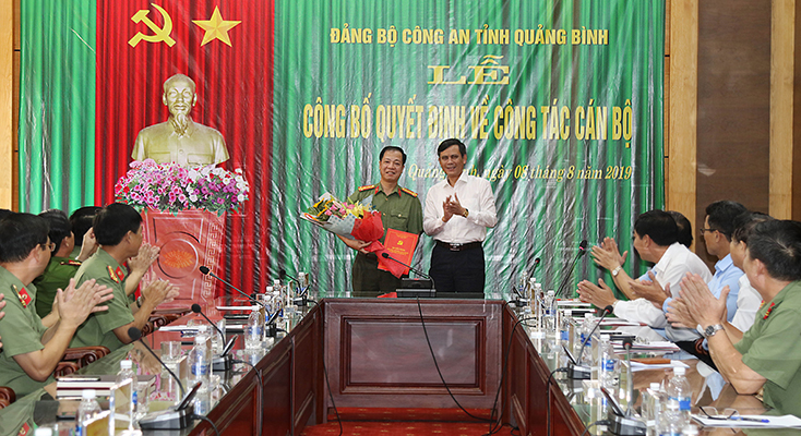 Đồng chí Phó Bí thư Thường trực Tỉnh ủy Trần Thắng trao quyết định và tặng hoa chúc mừng đại tá Trần Hải Quân.