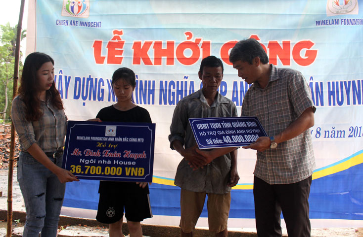 Ông Bùi Anh Tuấn, Chủ tịch UBND huyện Minh Hóa và đại diện các nhà tài trợ trao tiền cho gia đình ông Huynh tại lễ khởi công.