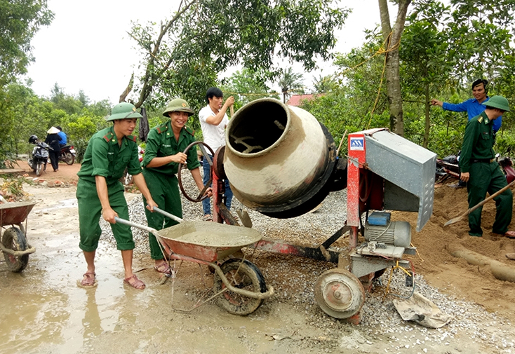 Cán bộ, chiến sỹ Đồn Biên phòng Ngư Thủy giúp đỡ ngày công làm sân bóng chuyền thôn Nam Hải, xã Ngư Thủy Trung.