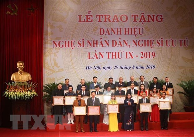 Phó Chủ tịch nước Đặng Thị Ngọc Thịnh trao danh hiệu Nghệ sỹ Ưu tú cho các nghệ sỹ. (Ảnh: Thanh Tùng/TTXVN)