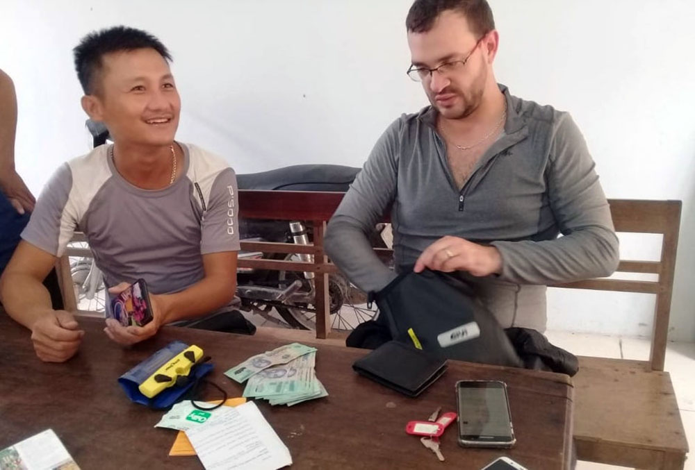 Anh Trần Đình Hưng (bên trái) và du khách vui mừng nhận lại tài sản bị đánh rơi