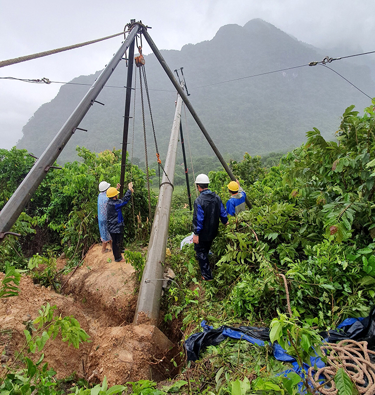 Công nhân Điện lực Đồng Hới dựng lại cột điện bị đổ, bảo đảm cấp điện trở lại cho xã Trường Sơn.