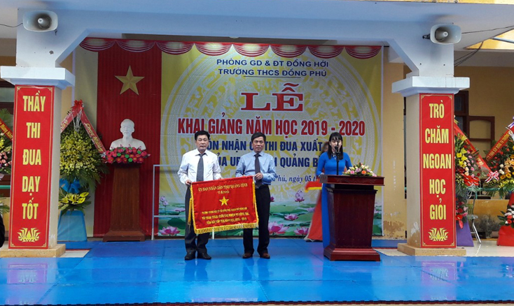 Đồng chí Lê Văn Phúc, Ủy viên Ban Thường vụ Tỉnh ủy, Bí thư Thành ủy Đồng Hới trao cờ thi đua xuất sắc dẫn đầu cấp học cho Trường THCS Đồng Phú