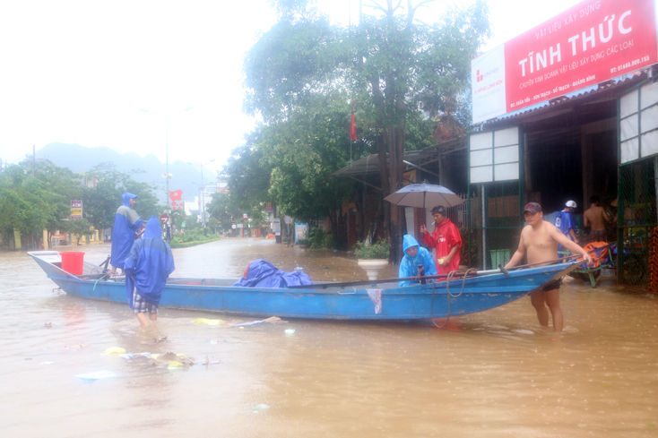 Người dân xã Sơn Trạch dùng thuyền hỗ trợ nhau di dời người và tài sản đến nơi an toàn.