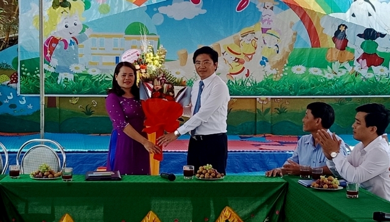 Đồng chí Trương An Ninh, Bí thư thị ủy Ba Đồn tặng hoa và chúc mừng tập thể Trường mầm non Quảng Minh.