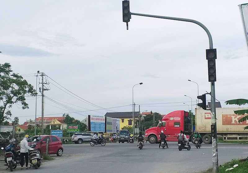 Người và phương tiện tham gia giao thông trên đường Hà Huy Tập dừng giữa lòng đường để tránh xe ô tô lưu thông trên đường tránh thành phố Đồng Hới