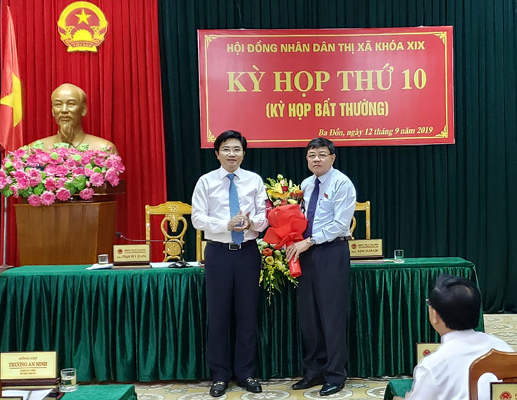 Đồng chí Trương An Ninh, Ủy viên Ban thường vụ Tỉnh ủy, Bí thư Thị ủy Ba Đồn tặng hoa chúc mừng đồng chí Đoàn Minh Thọ nhận nhiệm vụ.