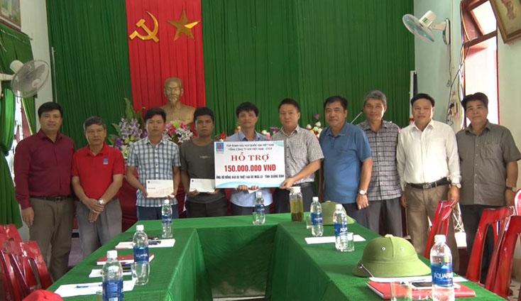 Đại diện lãnh đạo huyện Minh Hóa tiếp nhận tiền và quà do Tổng công ty khí Việt Nam hỗ trợ.