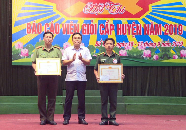 Bí thư Huyện ủy Bố Trạch Đinh Hữu Thành trao giải A cho 2 báo cáo viên xuất sắc.