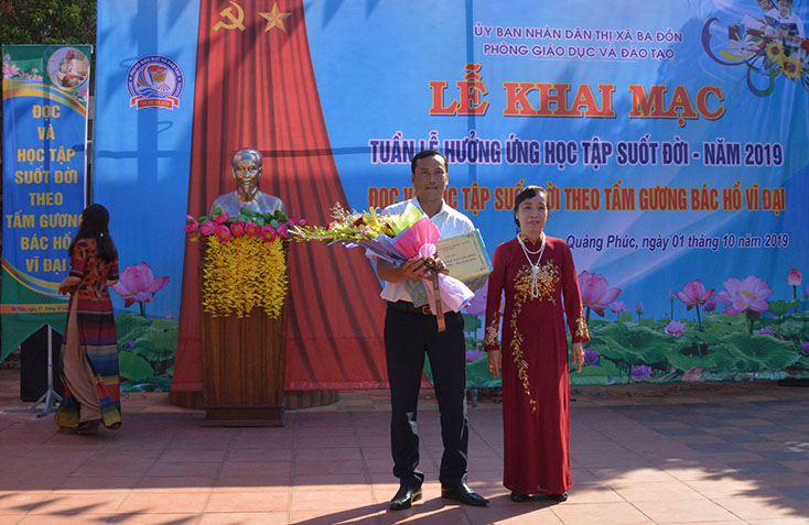 Bà Phạm Thị Bích Lựa, Chủ tịch Hội Khuyến học tỉnh tặng hoa và quà cho Trường THCS Quảng Phúc (thị xã Ba Đồn).