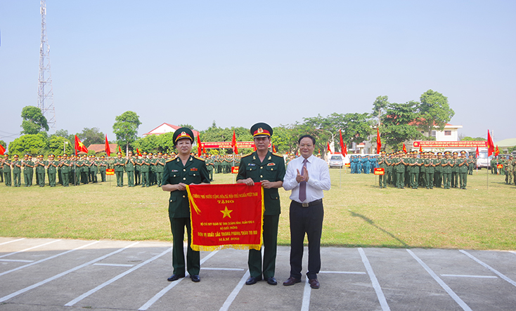 Đồng chí Phó Chủ tịch UBND tỉnh Lê Minh Ngân trao cờ thi đua xuất sắc của Thủ tướng Chính phủ cho Bộ CHQS tỉnh.