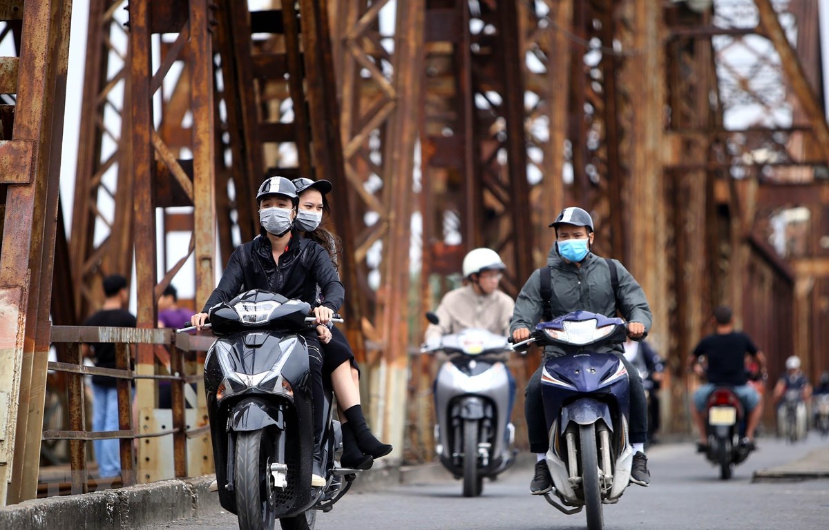 Người dân với trang phục áo ấm đi trên cầu Long Biên (Hà Nội). (Ảnh: Danh Lam/TTXVN)