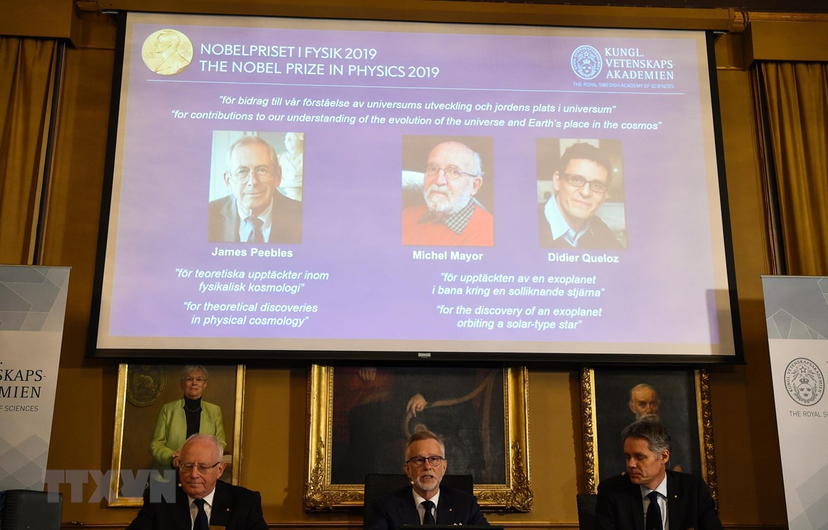 Ba nhà khoa học đoạt giải Nobel Vật lý 2019 (phía trên màn hình, từ trái sang): James Peebles, Michel Mayor và Didier Queloz được xướng danh tại Viện Khoa học Hoàng gia Thụy Điển Karolinska ở Stockholm ngày 8/10/2019. (Nguồn: AFP/TTXVN)