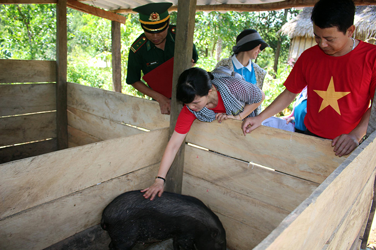 Đại diện Hội LHPN thành phố Đồng Hới và Đồn Biên phòng CKQT Cha Lo tặng lợn giống cho hộ chị Hồ Thị Coong.